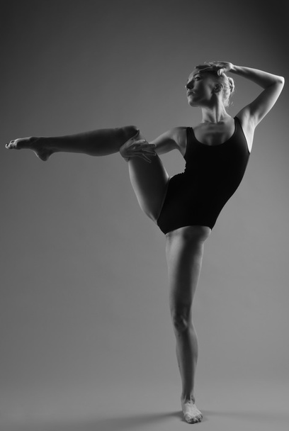 Pózol a sötét háttér előtt modern balett-táncos - Fotó, kép