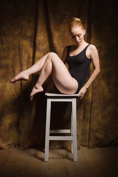 Σύγχρονο μπαλέτο χορεύτρια θέτουν σε σκοτεινό εσωτερικό - Φωτογραφία, εικόνα