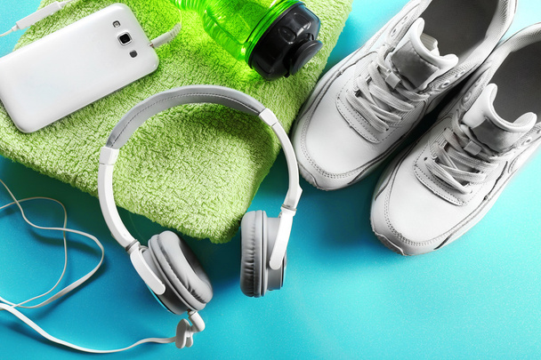 Headphones and sport equipment on blue background - Fotografie, Obrázek