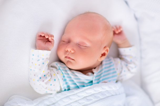Χαριτωμένο νεογέννητο μωρό σε λευκό κρεβάτι - Φωτογραφία, εικόνα