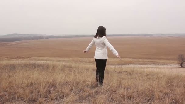 woman comes to the ravine her arms in nature open plain autumn - Footage, Video