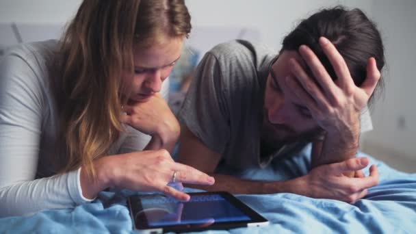 férfi és nő használ egy tablettát, míg szóló ágyban - Felvétel, videó