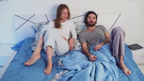 funny man and woman in bed looking to camera - Video, Çekim