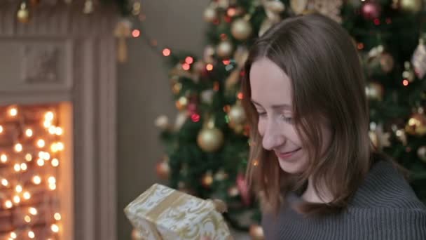 Boldog fiatal nő karácsonyi jelen dobozának kinyitása - Felvétel, videó