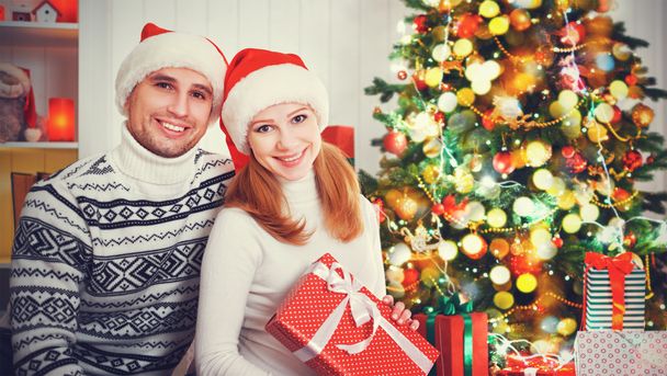 happy  family couple with a gift on Christmas at home - Фото, изображение