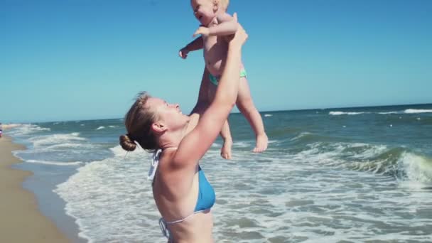 moeder haar kind op het strand slow motion overgeven - Video
