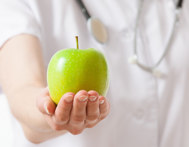 Doctor holding fresh green apple - Фото, изображение
