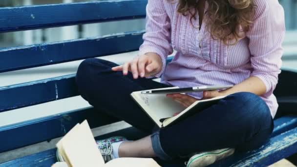 vrouwelijke student zittend op een bankje en het gebruik van Tablet PC Slowmotion - Video