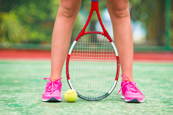 Close-up van schoenen met het tennis racket en bal buitenleven op rechter - Foto, afbeelding