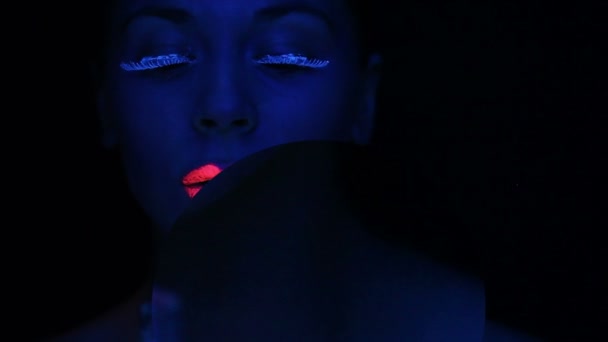 Twarz kobiety z fluorescencyjny makijaż - Materiał filmowy, wideo