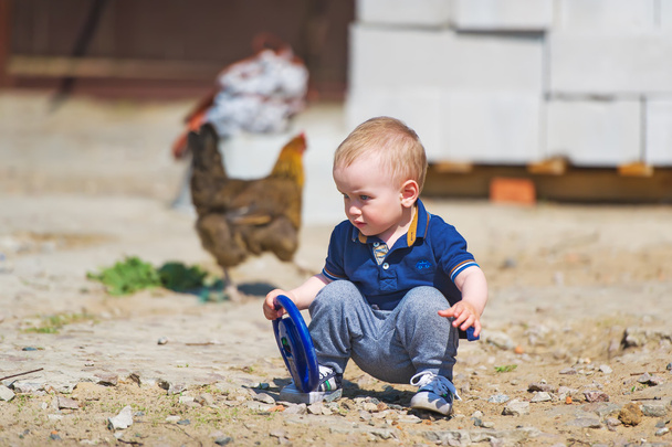 Милий маленький хлопчик грає в саду
 - Фото, зображення