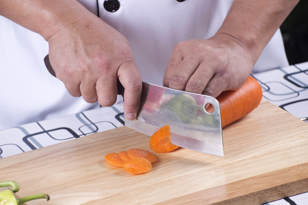 Chef-kok snijden wortel  - Foto, afbeelding