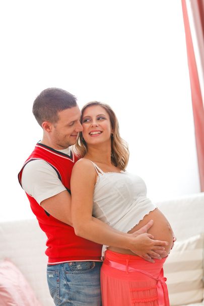 妊娠中の女性の夫彼女のおなかを抱き締めると肖像画 - 写真・画像