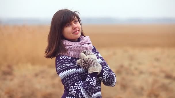 portret kobiety w sweter i rękawice na jesień natura zimno suchej trawy - Materiał filmowy, wideo
