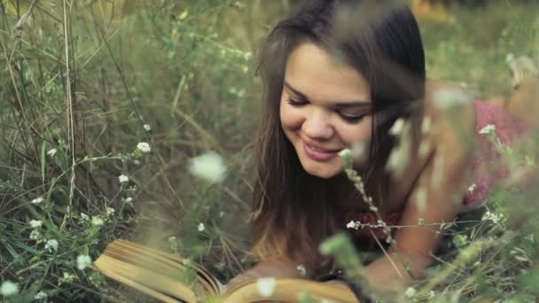 mladá žena stanoví v oblasti květin a čte knihu Zpomalený pohyb - Záběry, video