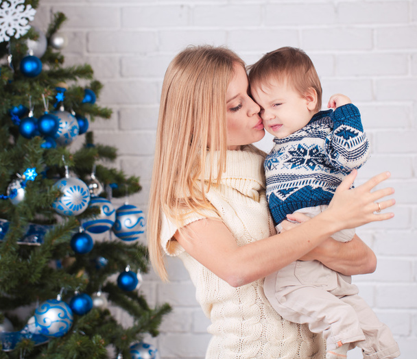 Madre con hijo cerca del árbol de Navidad
 - Foto, Imagen