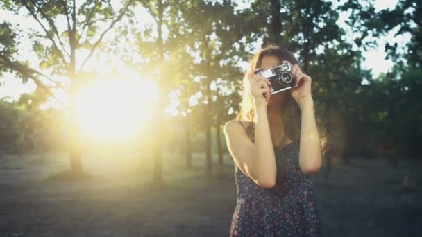 jonge vrouw neemt foto's met een oude camera slow motion - Video