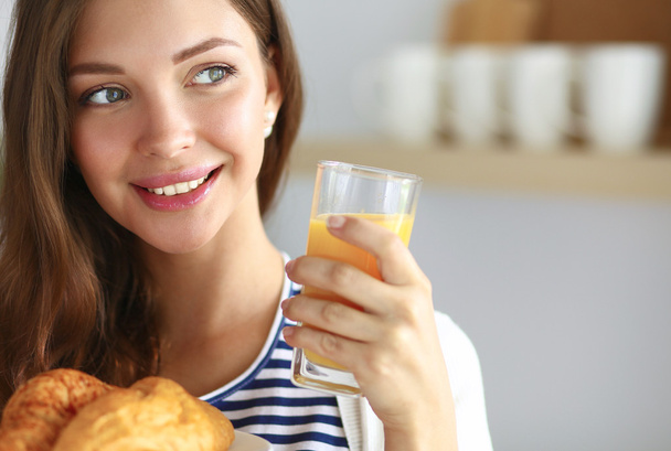 Young woman with glass of juice and cakes - Фото, изображение