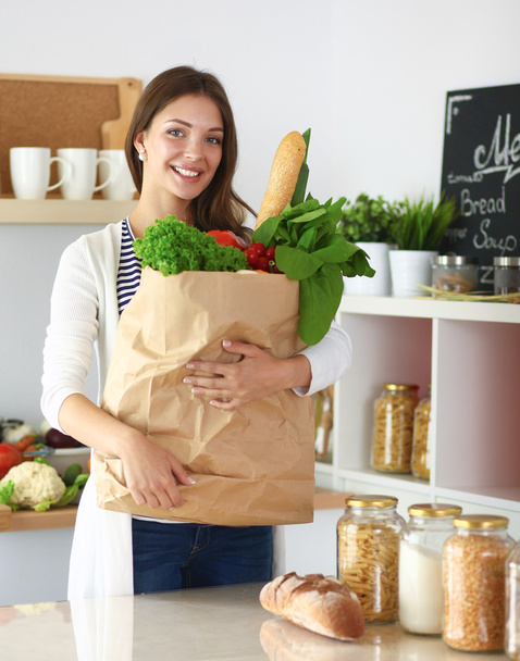Jonge vrouw met boodschappentas met groenten - Foto, afbeelding
