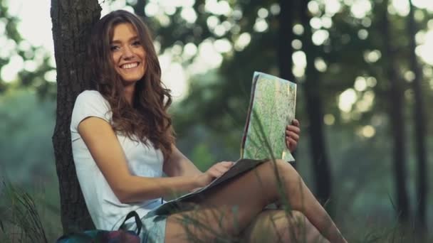 young female with a map smiles looks to a camera slow motion - Footage, Video
