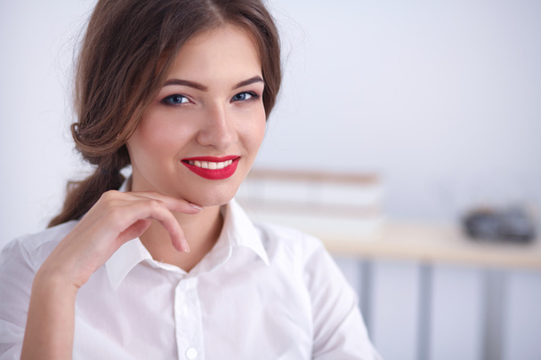 Atractiva joven empresaria sentada en la oficina
 - Foto, Imagen