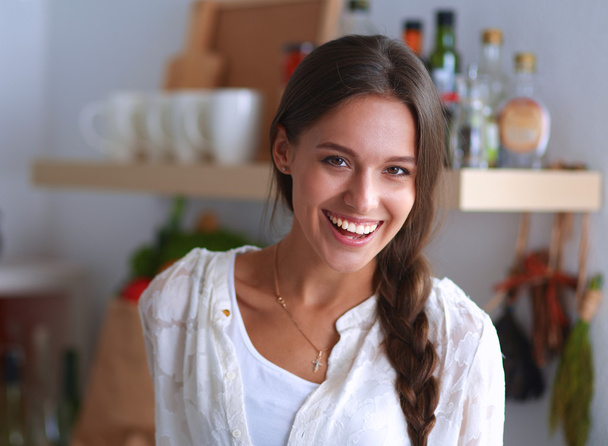 Young woman standing near desk in the kitchen - Fotografie, Obrázek