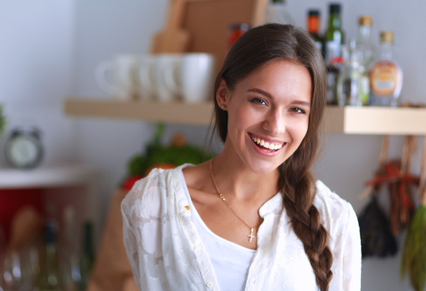 Young woman standing near desk in the kitchen - Zdjęcie, obraz