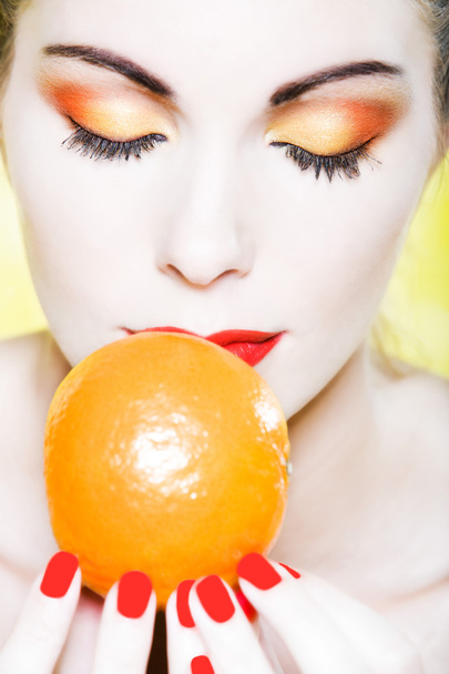 Woman portrait smelling a mandarin - 写真・画像