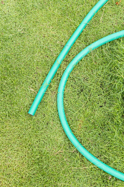 Grüner Gartenschlauch auf grünem Gras - Foto, Bild