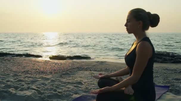 joven hembra medita en la playa cámara lenta
 - Imágenes, Vídeo