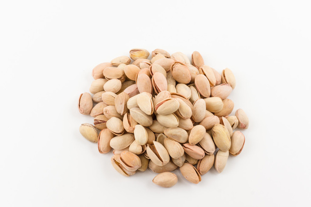 hill of pistachios in a shell lies on a white background - Photo, Image
