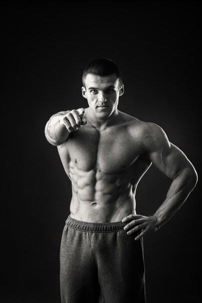 bodybuilder professionnel montre son corps sur un fond sombre
 - Photo, image