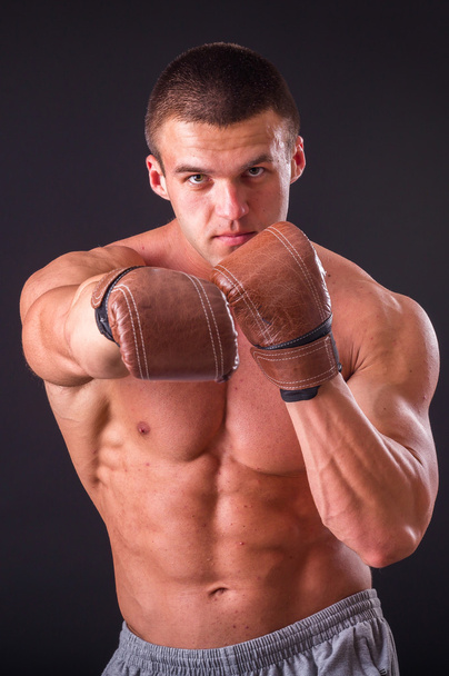 Uomo muscoloso in giacca sportiva su sfondo scuro
 - Foto, immagini