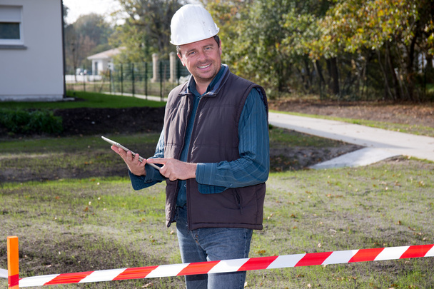 Entrepreneur on construction site using electronic tablet - Foto, afbeelding