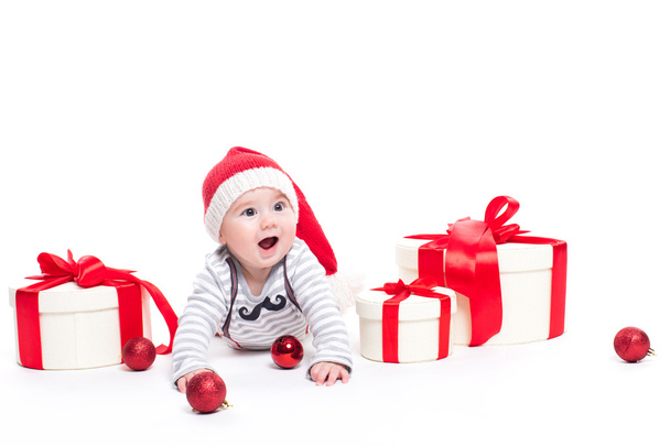Cute baby in a red New Year's cap with a smile on his face lying - Photo, Image