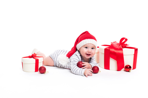 Lindo bebé con una gorra roja de Año Nuevo con una sonrisa en su cara acostada - Foto, imagen