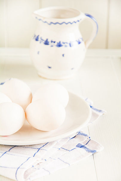 Сырые яйца лежат на тарелке
 - Фото, изображение