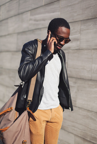 Handsome confident young african man talking on smartphone in ci - 写真・画像