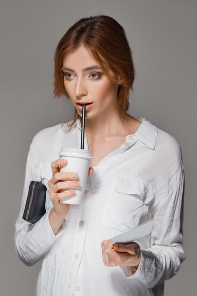 red hair girl drinks through straw from the glass - Valokuva, kuva
