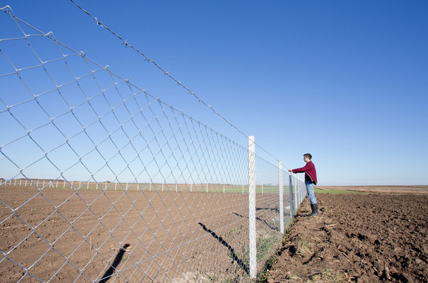 Человек держит забор из колючей проволоки
 - Фото, изображение