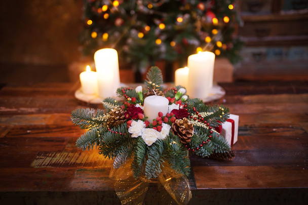 Fir branches decorated for the new year on dark wooden background. Christmas tree and candles, festive mood - Photo, Image