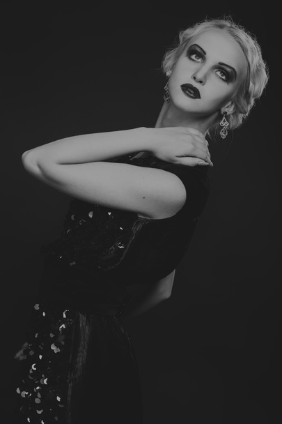 Mooie blonde in vintage jurk op een donkere achtergrond - Foto, afbeelding