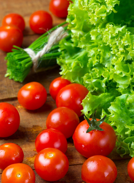 トマトと木製の暗い背景に緑の野菜 - 写真・画像