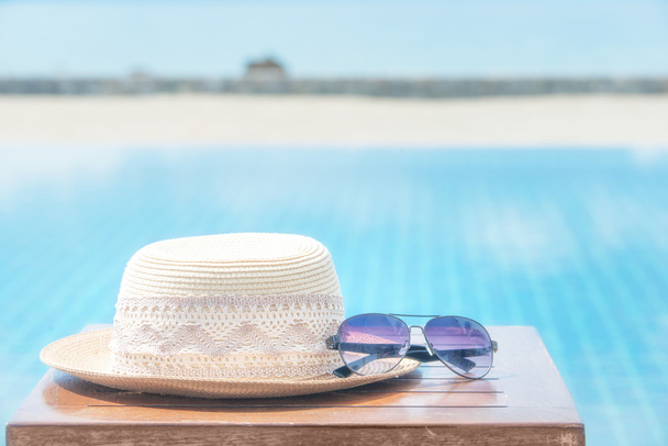 Καπέλο και γυαλιά ηλίου στο βάθος θάλασσας - Φωτογραφία, εικόνα