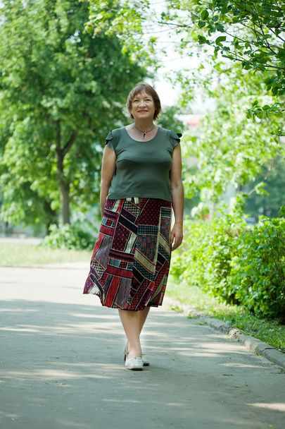 Mature woman walking in park - Zdjęcie, obraz