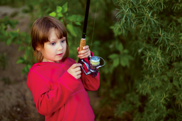 Little girl fishing with spinning - Фото, зображення