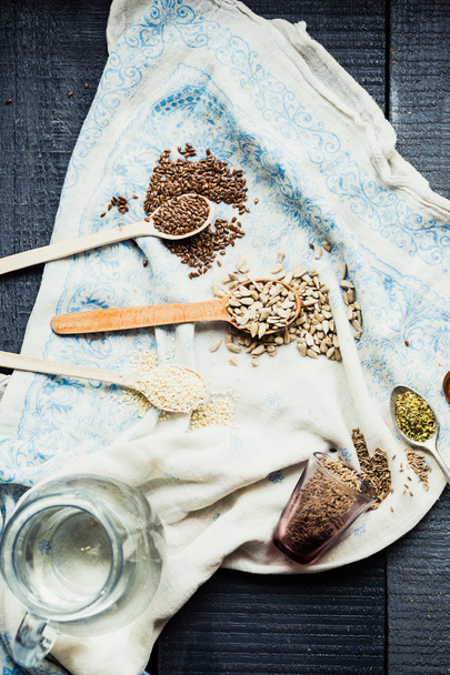 flax seeds, sesame seeds, sunflower seeds in wooden spoons and - Фото, зображення