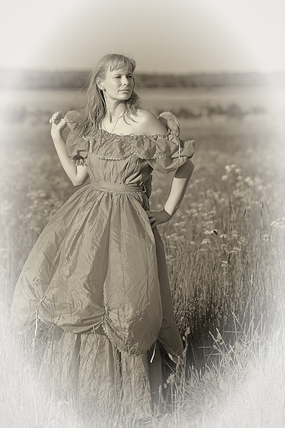 Young woman in an retro dress in the field - Fotoğraf, Görsel