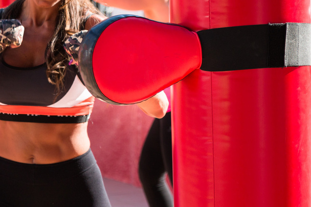 Menina jovem e vermelho perfurando sacos e luvas, boxe e fitness
 - Foto, Imagem
