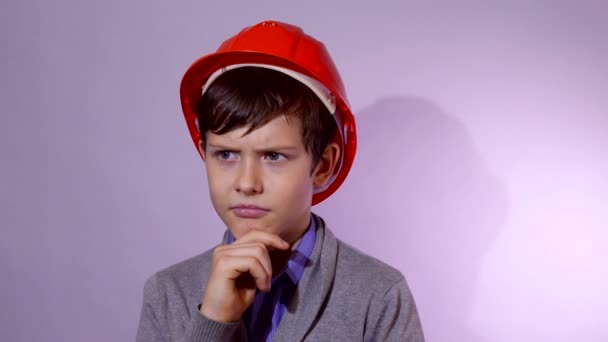 Teen Boy Baumeister in orangefarbenem Helm Ich denke, Problem Studio Porträt - Filmmaterial, Video
